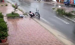 Nam sinh dừng xe móc rác khơi thông miệng cống lúc trời mưa