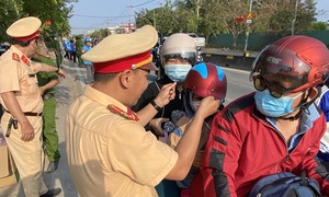 TPHCM: Công an tặng mũ bảo hiểm, nước suối cho người dân về quê đón Tết