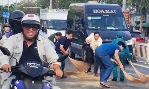 Lãnh đạo phường cùng dân quân xử lý dầu loang trên đường giúp người dân lưu thông an toàn